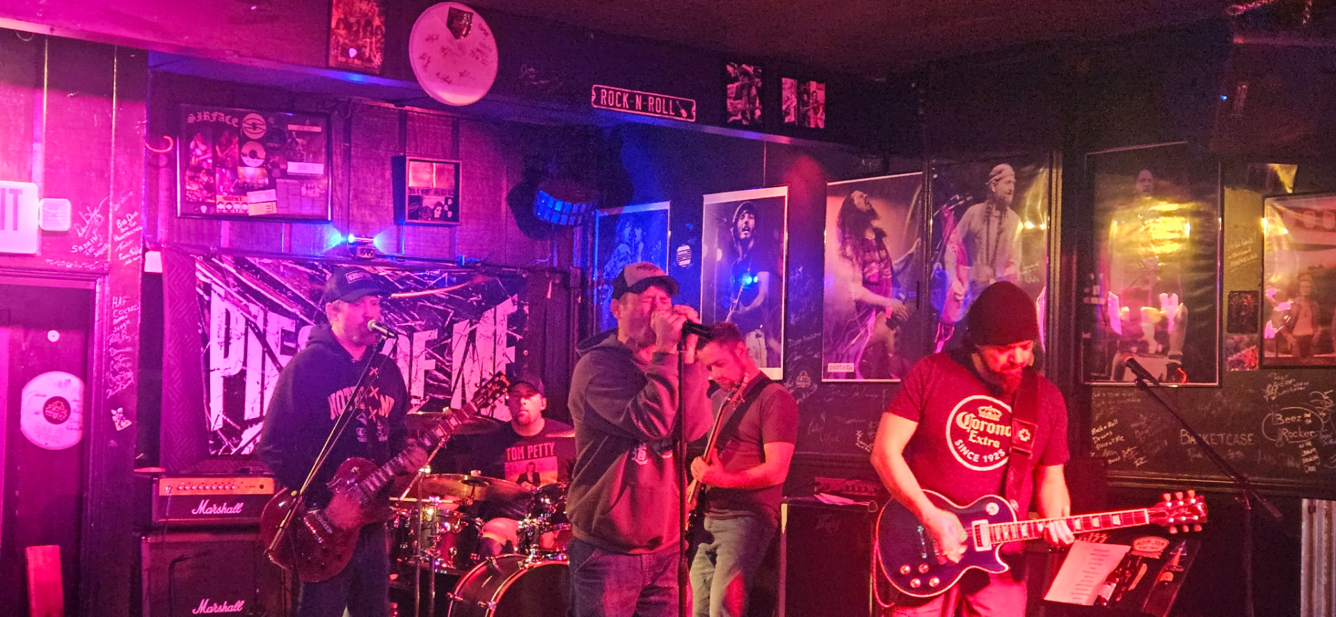 Piece of Me performing under red and purple stage lights in a rock bar